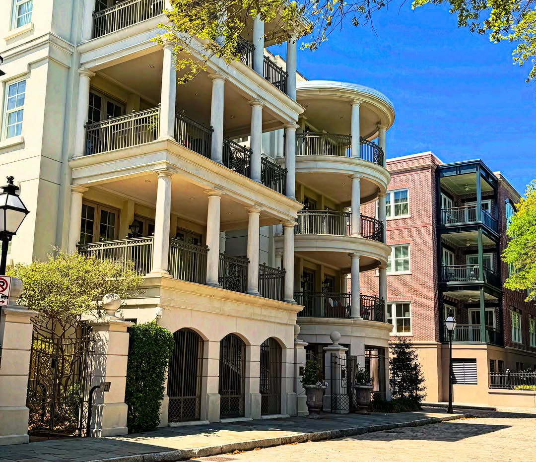 A sunny street with white and brick apartment buildings featuring balconies and tall columns—perfect for families exploring things to do in Charleston with kids.