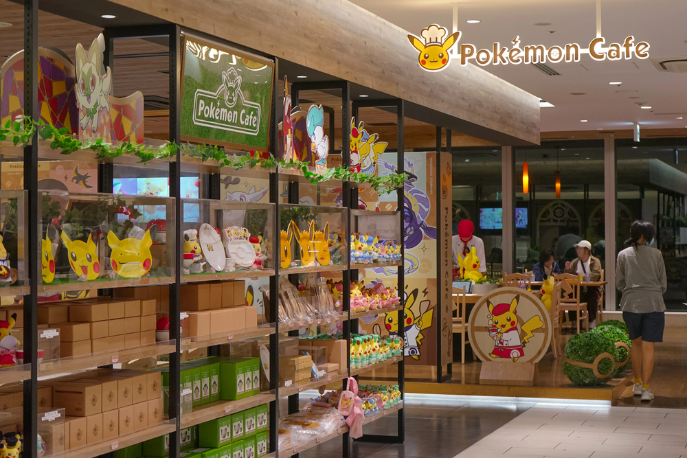A Pokémon Café with themed decor, shelves of Pokémon merchandise, and people dining inside—an essential stop for anyone traveling in Japan.