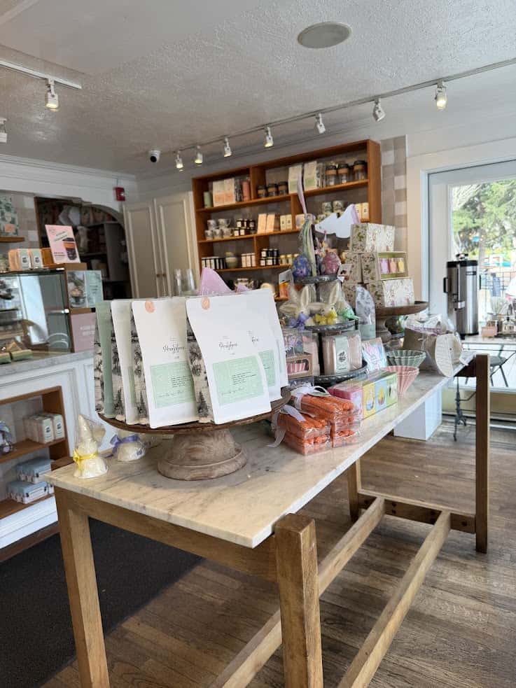 A display table in a cozy shop with gift bags, candy, and treats&mdash;like a scene straight out of a Jackson Hole travel guide&mdash;sits invitingly, with shelves stocked in the background.