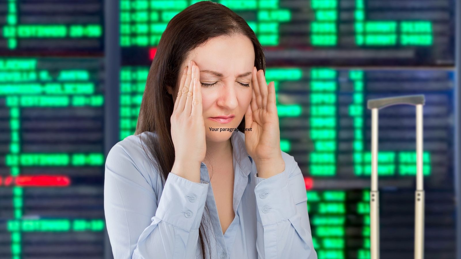Woman holding her head in frustration in front of a flight information board at an airport.
