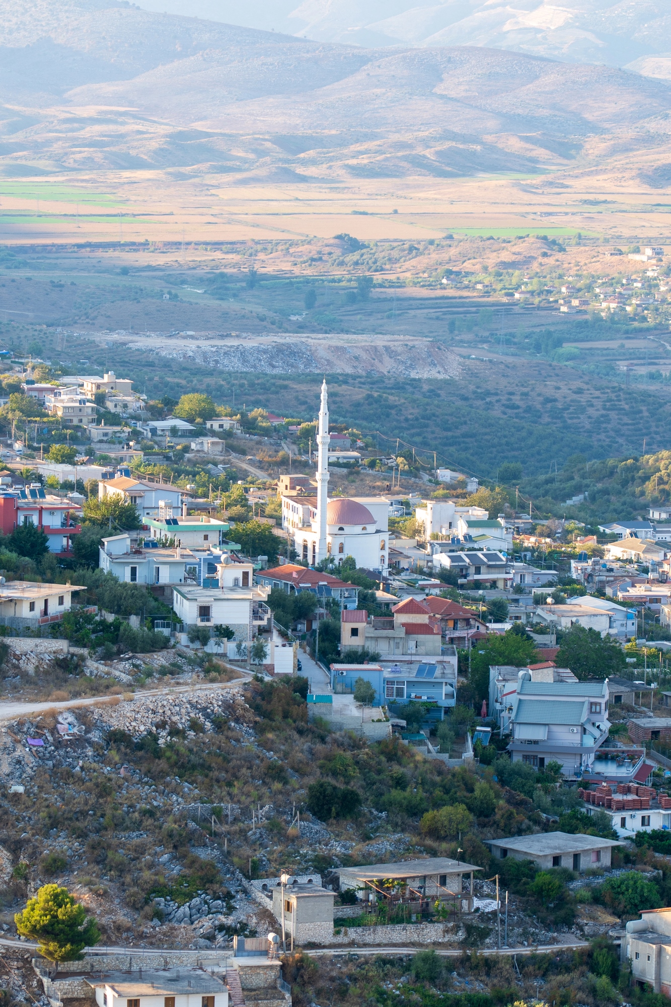 A village with houses, a mosque with a tall minaret, and mountains in the background under a clear sky&mdash;this picturesque scene could be mistaken for one of those hidden european destination dupes that promise beauty without the crowds.