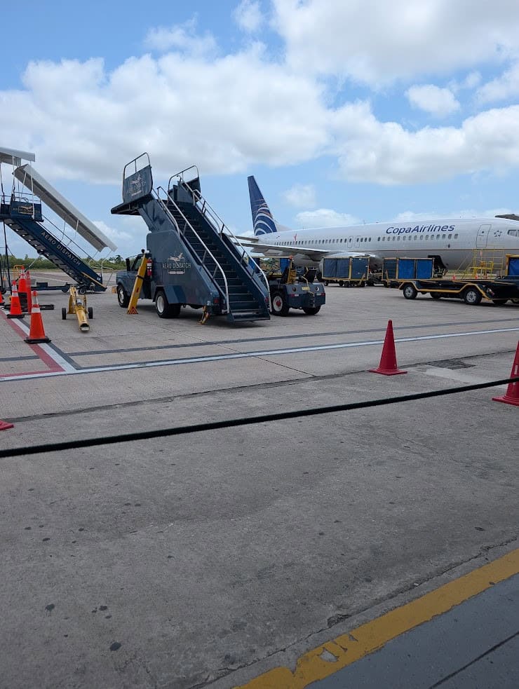 Copa Airlines plane on tarmac with mobile stairs and orange cones under a partly cloudy sky, evoking the sense of adventure captured in a The Rainforest Lodge at Sleeping Giant Review.