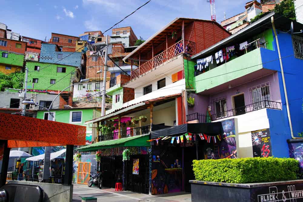 Colorful hillside houses with balconies, laundry drying, and blue sky above create a vibrant scene in this lively urban neighborhood—one of the many sights to discover while exploring things to do in Medellin with kids.
