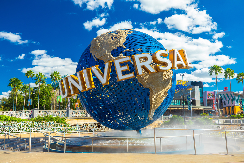 Large blue Universal globe statue with gold letters, surrounded by palm trees and a bright blue sky—an iconic spot and a must-see for families searching for things to do in Orlando with kids.