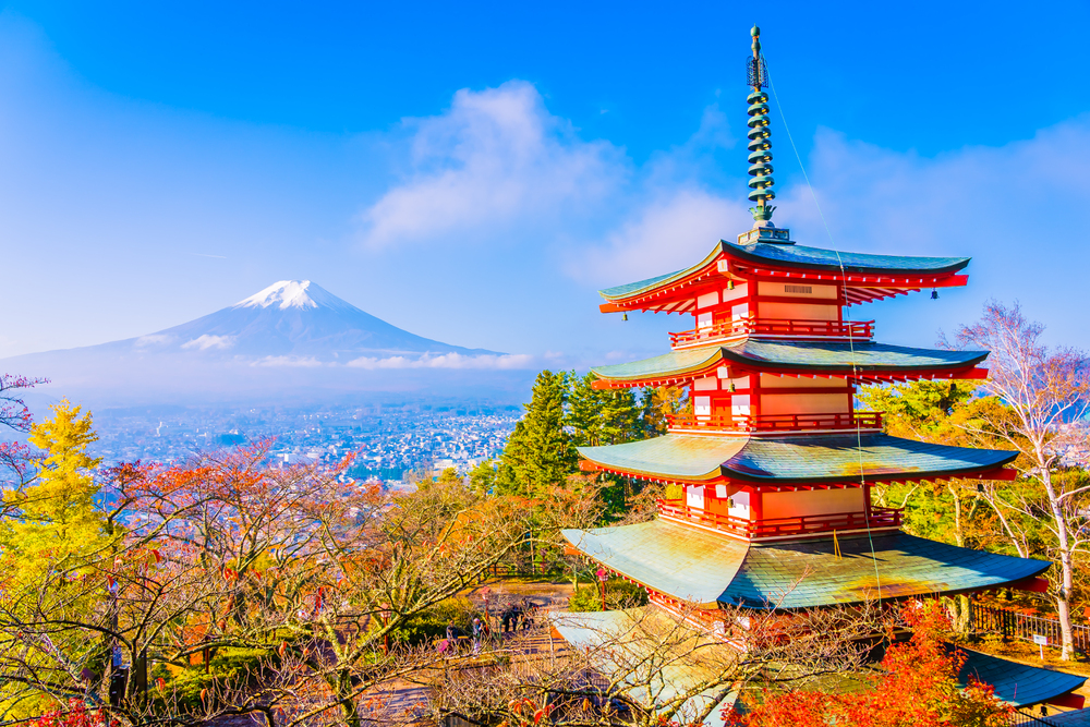 Red pagoda with Mount Fuji in the background, surrounded by autumn trees under a clear blue sky—a perfect setting for those looking to travel with teens and experience breathtaking views together.