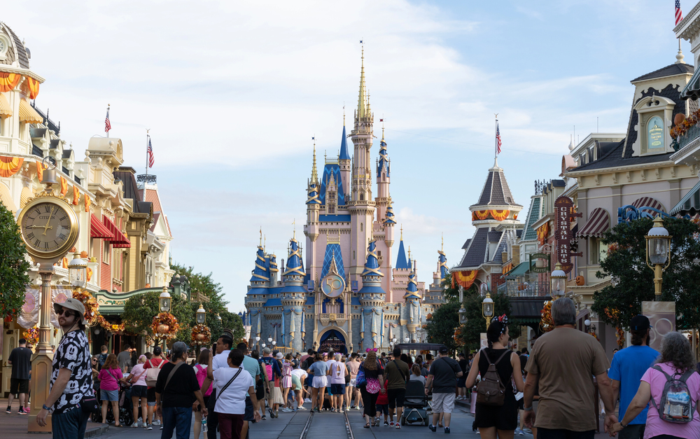 Crowds walk toward Cinderella Castle at Disney World, surrounded by shops and decorations on Main Street, U.S.A.—one of the top things to do in Orlando with kids.