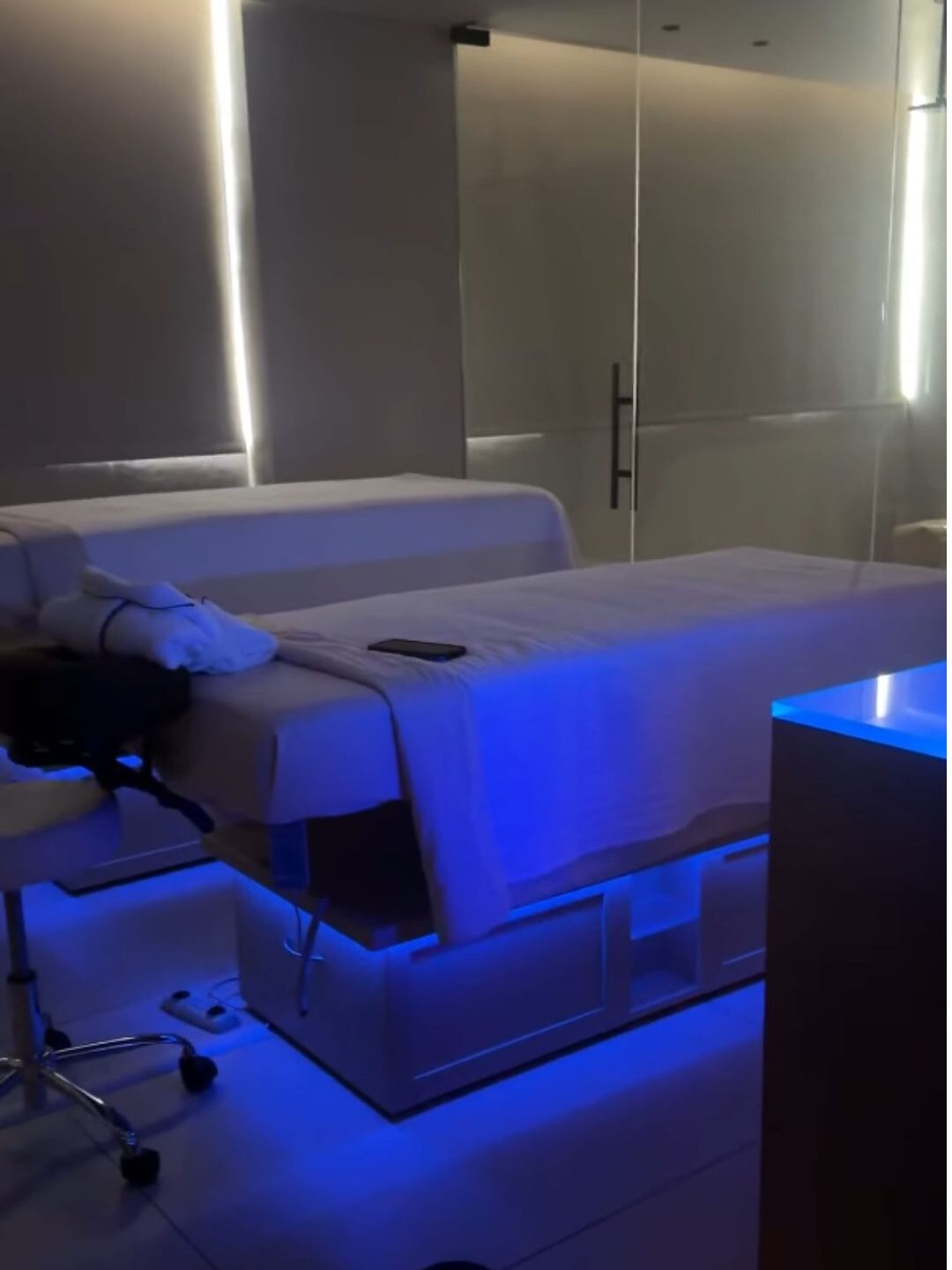 A modern spa room at Gale Miami Hotel & Residences features a massage table, soft lighting, and blue LED lights beneath the bed, creating a tranquil oasis—a detail often praised in many Gale Miami Hotel & Residences reviews.