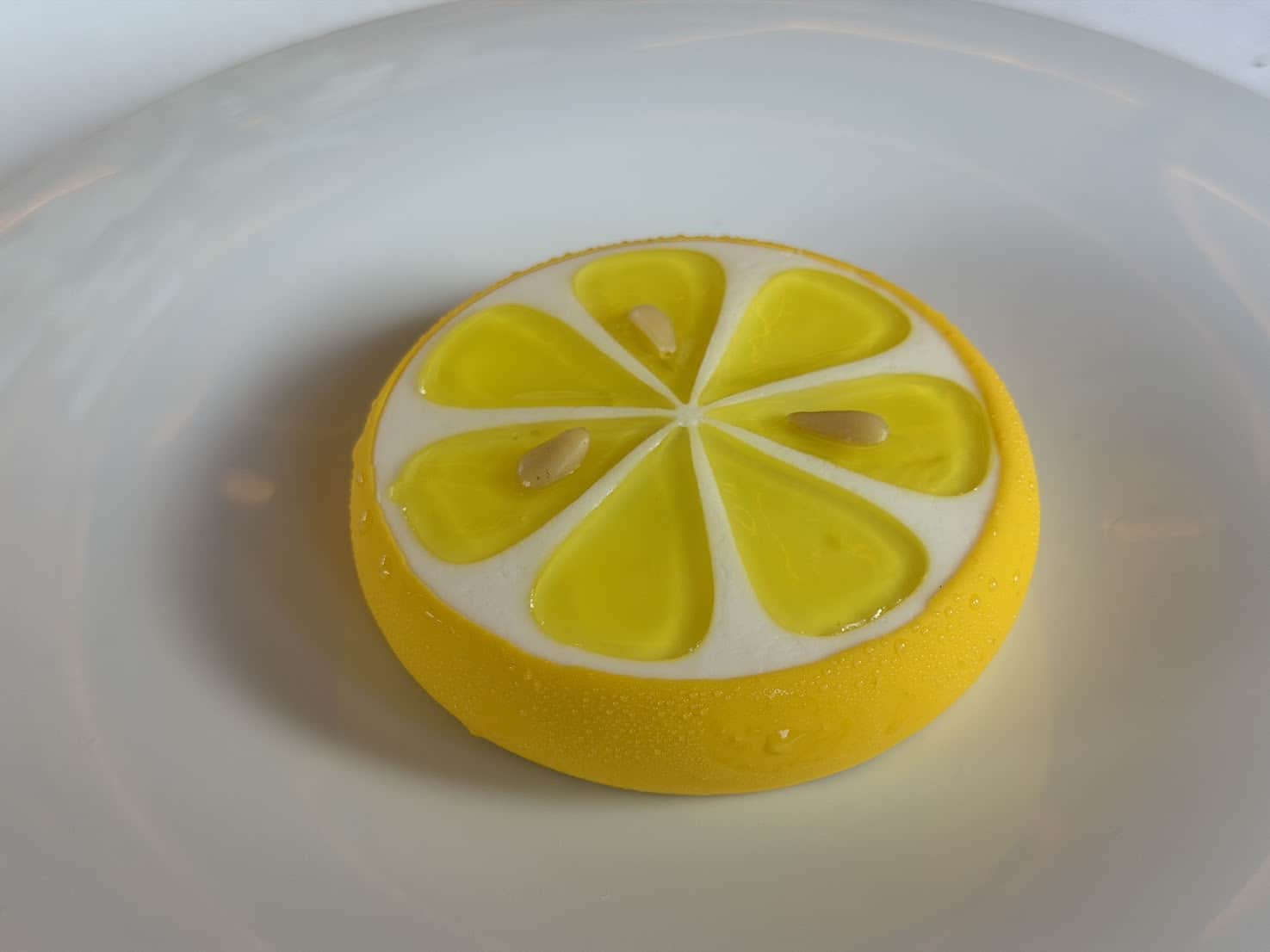 A lemon slice dessert on a white plate, as seen in a Seia Miami review.