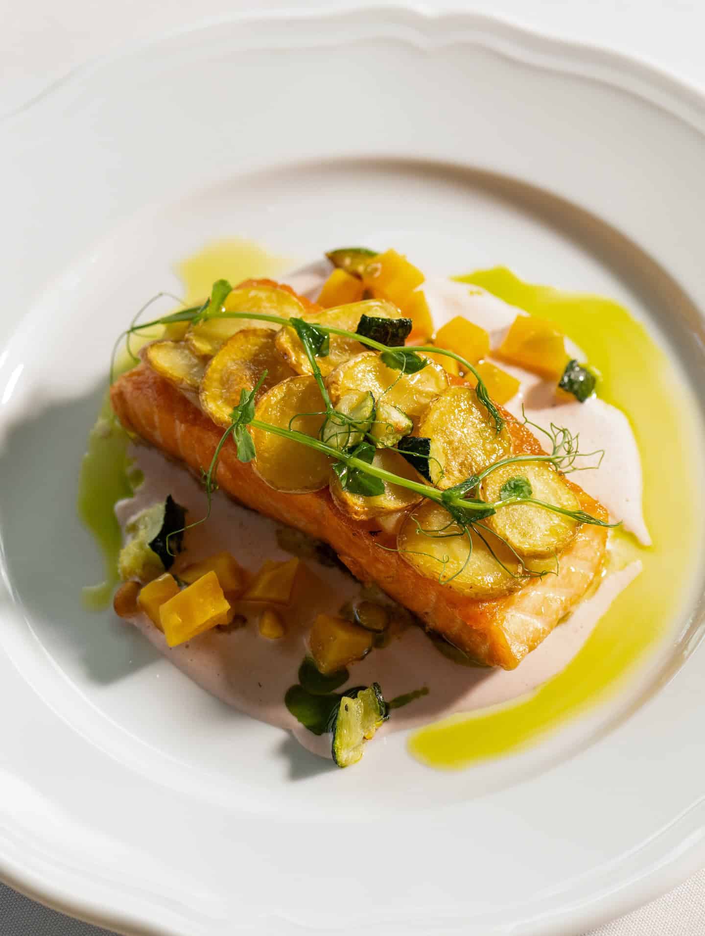 Pan-seared salmon with potatoes and herbs in cream sauce, as seen in a Seia Miami review.